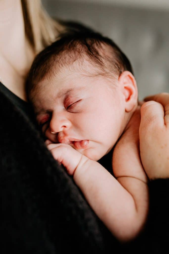 Close up of newborn baby girl sleeping and cuddling to mummy. Hampshire newborn photo shoot. Ewa Jones Photography