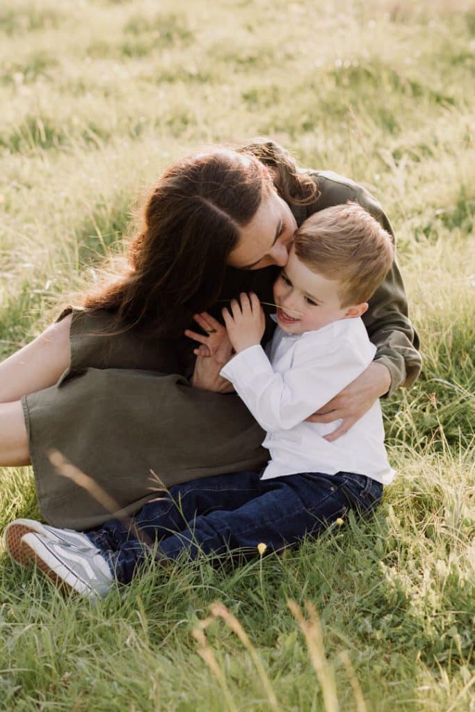 Claudia and Lorenzo-12 mum is cuddling her son and kissing him on his head. Lovely natural settings for mum and son photo session in Hampshire. Hampshire family photo sessions. Ewa Jones Photography