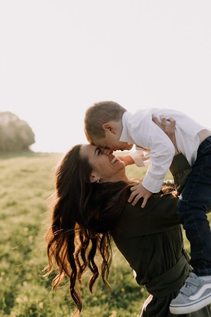 Claudia and Lorenzo-18 mum is lifting her baby boy and laughing with him. Hampshire photo shoot in the fields. Ewa Jones Photography. Hampshire photographer