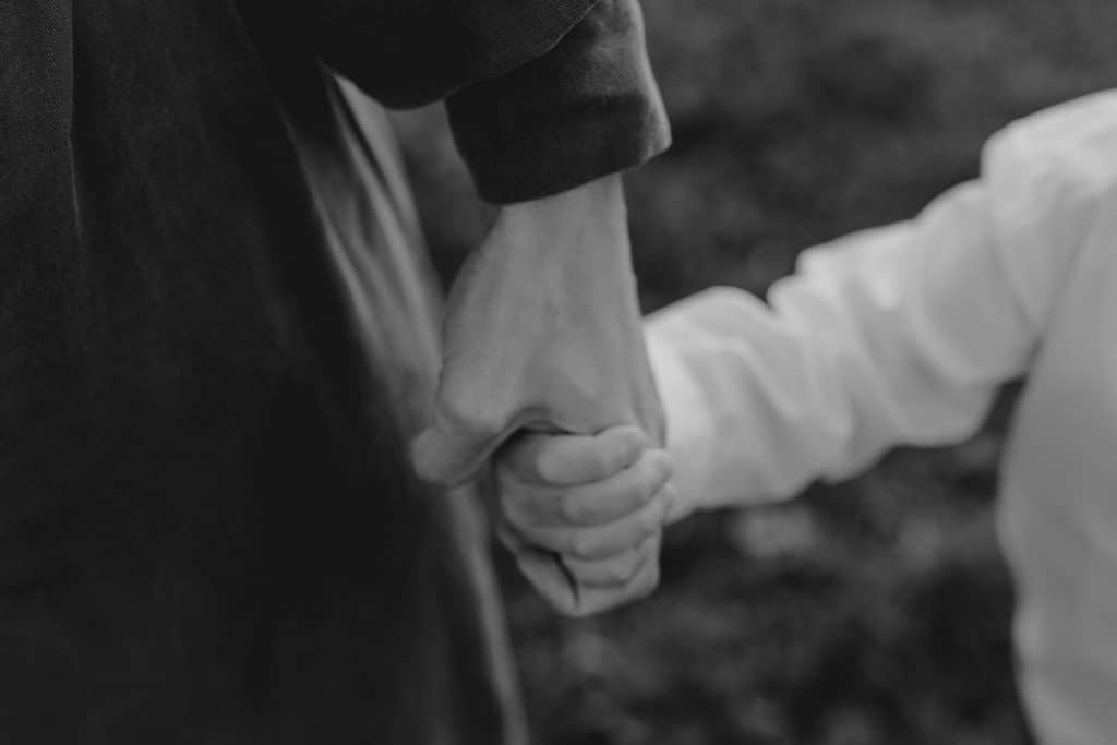Claudia and Lorenzo-20 mum and son are holding hands. Black and white candid photograph of love and connection. Hampshire photo shoot. Ewa Jones Photography