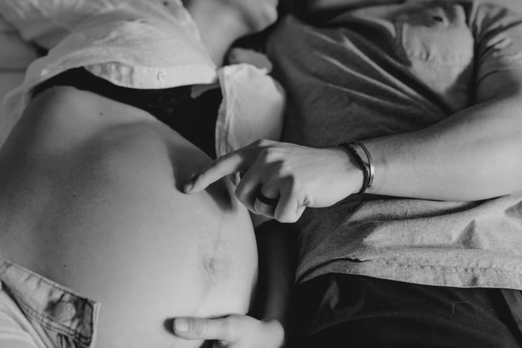 dad is tracing his finger on baby bump. black and white maternity photography. Maternity photo shoot. maternity photo session in Hampshire. Ewa Jones Photography