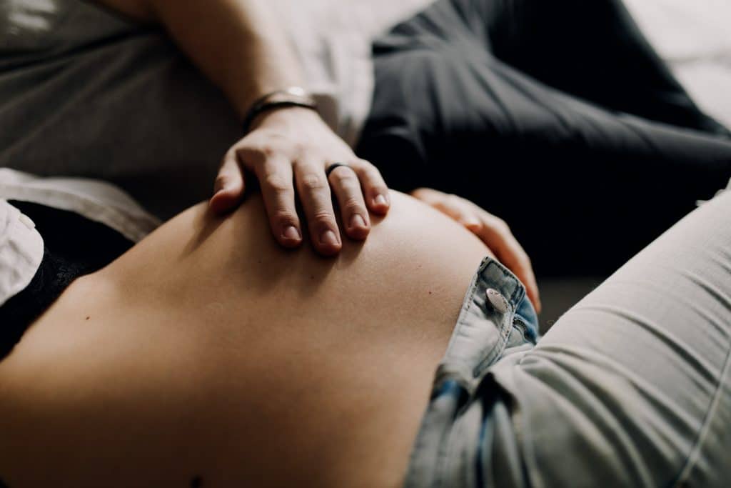 dad has his hand on baby bump. maternity photo session at home. Hampshire maternity photographer. Maternity photo shoot. Ewa Jones Photography