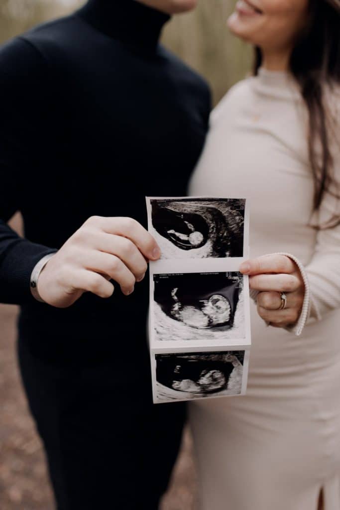 mum and dad are holding scan photo of their baby. Maternity photo session. Hampshire photographer. Hampshire maternity photo session. Ewa Jones Photography