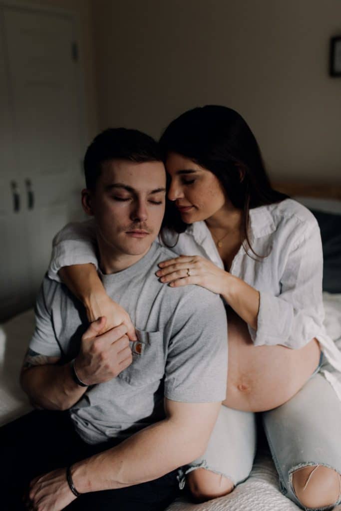 Mum is cuddling her husband close. Maternity photo session in Hampshire. maternity photoshoot. Maternity photographer in Hampshire. Ewa Jones Photography