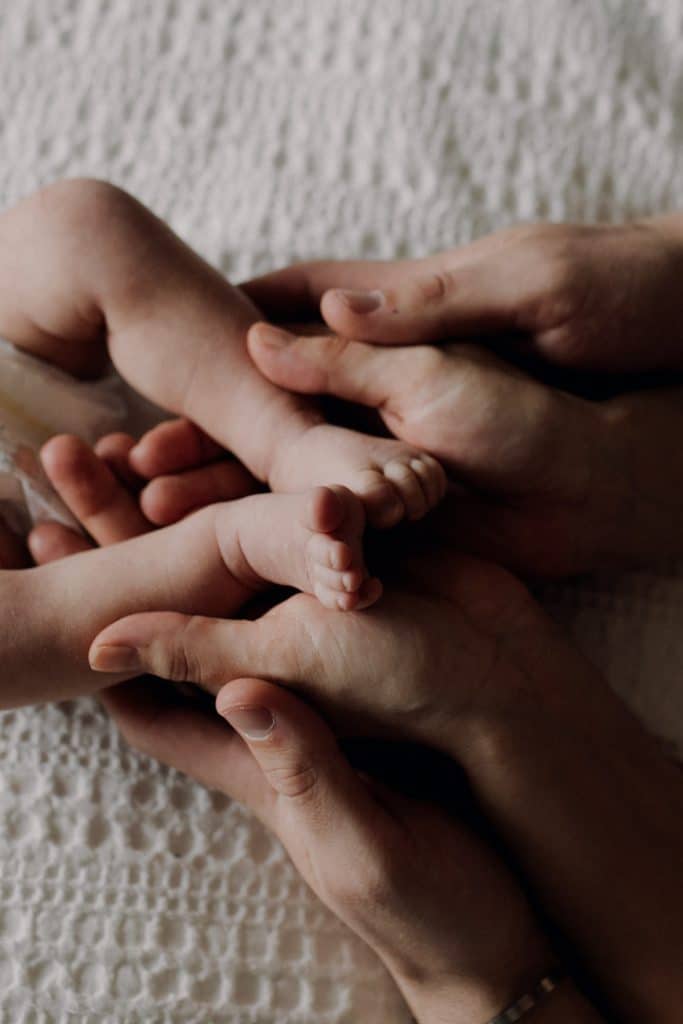 mum and dad are holding newbrn baby feet. in home newborn photo session. Basingstoke newborn photographer. Ewa Jones Photography