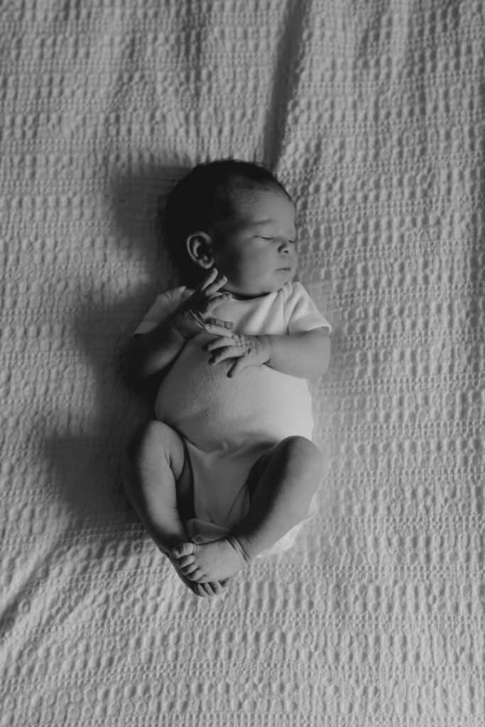 newborn baby is laying on the bed. newborn photo shoot at home. newborn photographer in Basingstoke. Hampshire photographer. Ewa Jones Photography