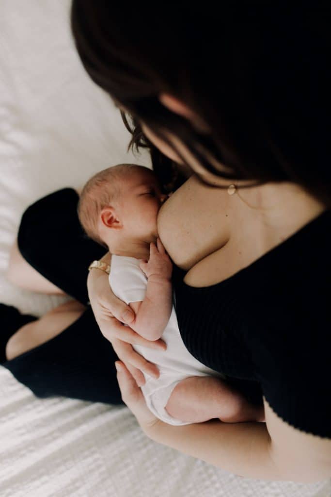 breastfeeding photo of mum feeding her baby. newborn photo session at home. newborn photographer in Hampshire. Basingstoke newborn photographer. Ewa Jones Photography