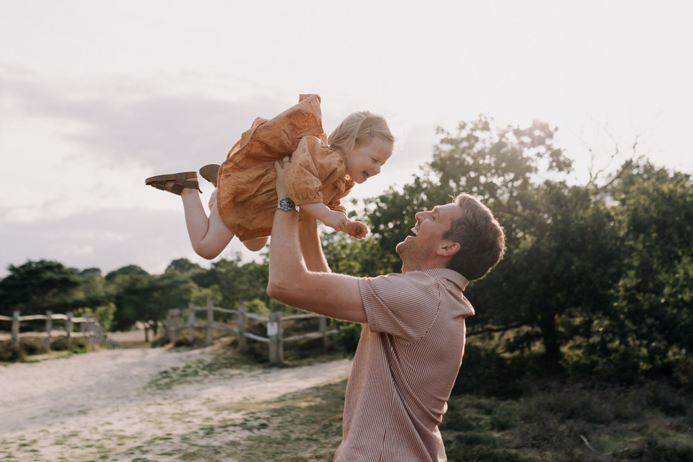 dad is lifting his daughter in the air. Family session in the sunshine. Outdoor lifestyle session. Ewa Jones Photography