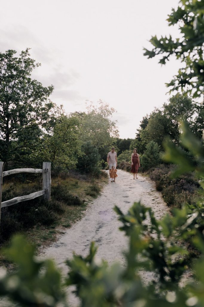 family of three are walking down in the nature reserve. Family photo session outside. Ewa Jones Photography