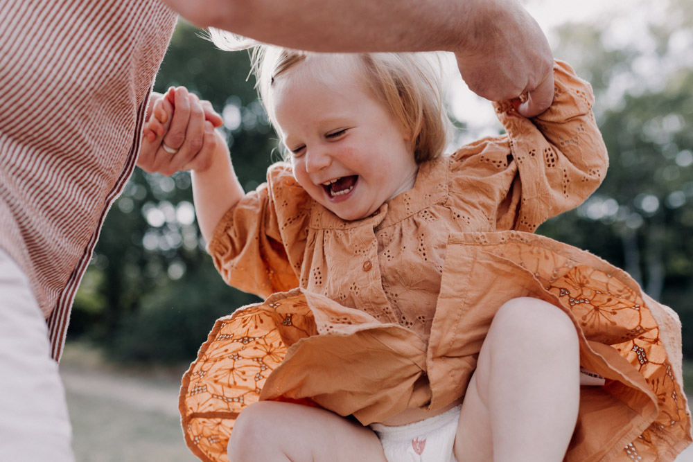 dad is lifting his daughter in the air. family photo shoot outdoors. Hampshire family photographer. Ewa Jones Photography