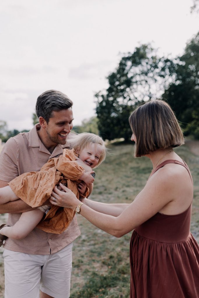 Mum and dad are laughing and the daugher is laughing too. Family photo session in six steps. Hampshire photo shoot. Ewa Jones Photography