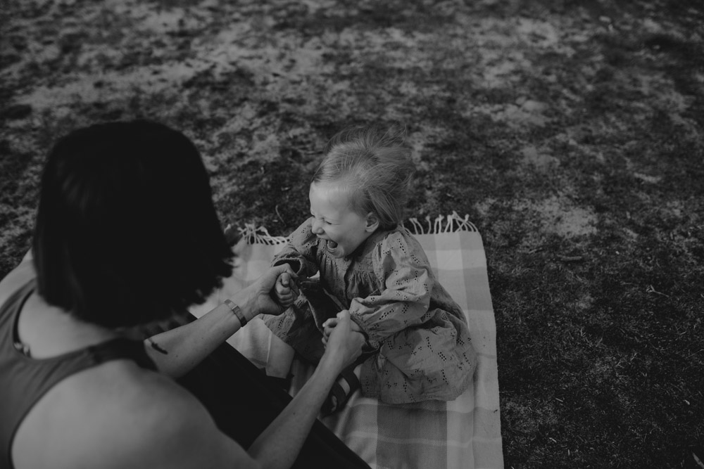 daughter is laughing and holding hands with mum. black and white photograph. Hampshire photo shoot. Ewa Jones Photography