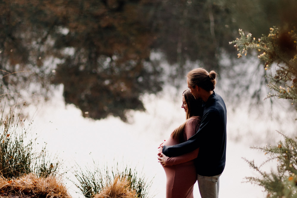 Maternity photo session in Basingstoke 06.12.24-14 Maternity photograph by the pond. parents to be are hugging. what to wear for maternity session. Ewa Jones Photography