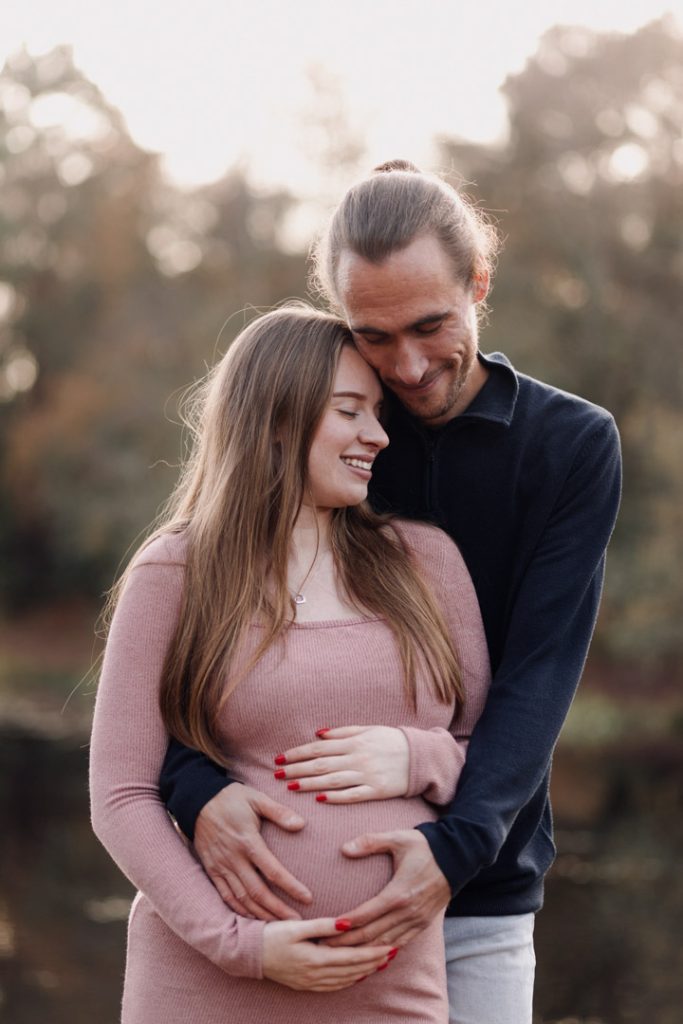 Maternity photo session in Basingstoke 06.12.24-2 expecting parents are holding tight to each other. Outside natural maternity photo session in Hampshire. What to wear for a maternity photo session. Ewa Jones Photography