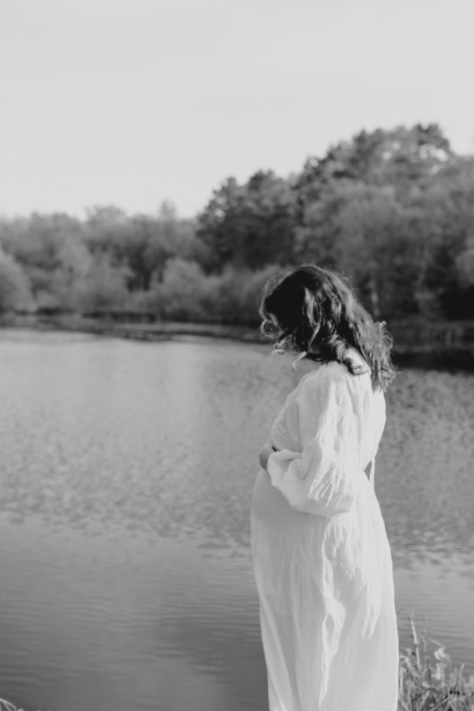 mum is looking down and away at baby bump. maternity photo session at the nature reserve. Hampshire maternity photo session. Hampshire photographer. Ewa Jones Photography