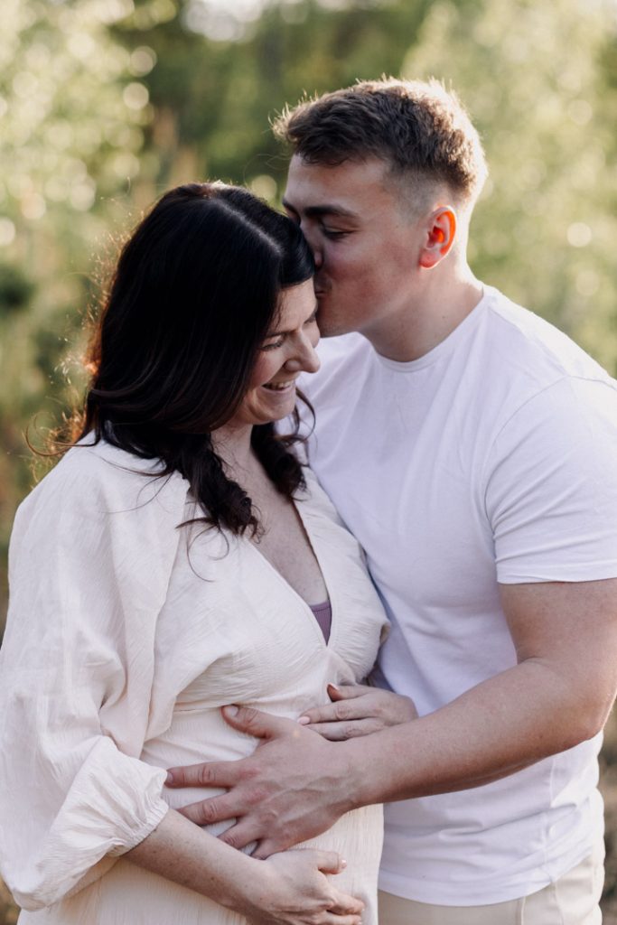 Dad to be is kissing mum to be. maternity session outdoor. Hampshire maternity photographer. Ewa Jones Photography