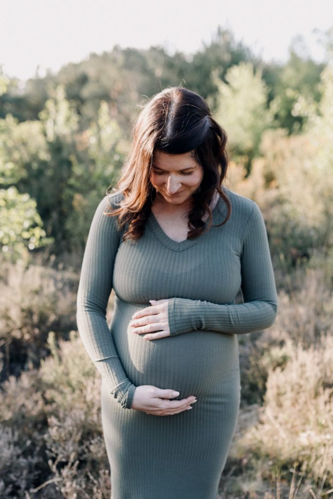 mum to be is wearing lovely green dress. maternity photo shoot. Ewa Jones Photography