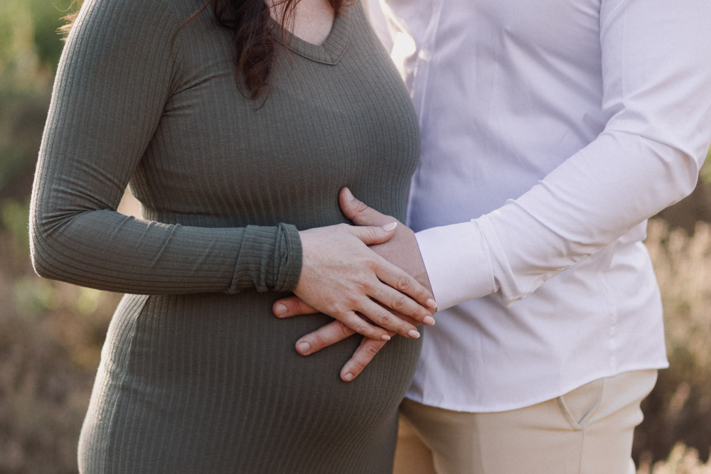 mum and dad are holding their hands on baby bump. Maternity session in Hampshire. Lifestyle maternity session. Ewa Jones Photography