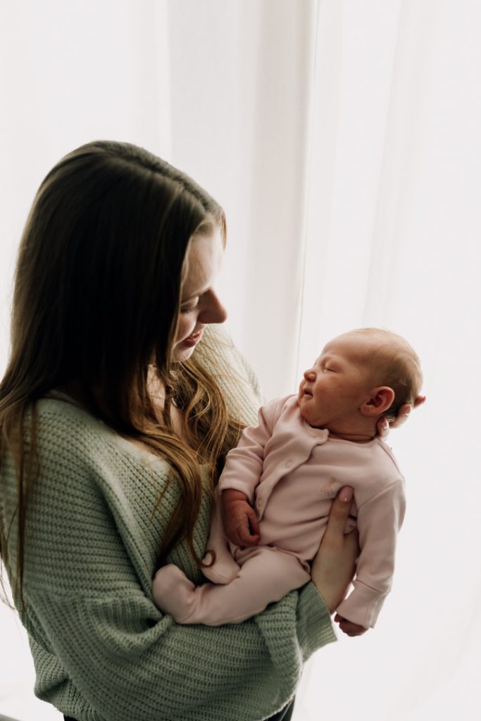 Newborn photo session in Basingstoke 19.01.24-11 mum is holding her daughter in her hands. lovely newborn session at home. Basingstoke photographer. Ewa Jones Photography