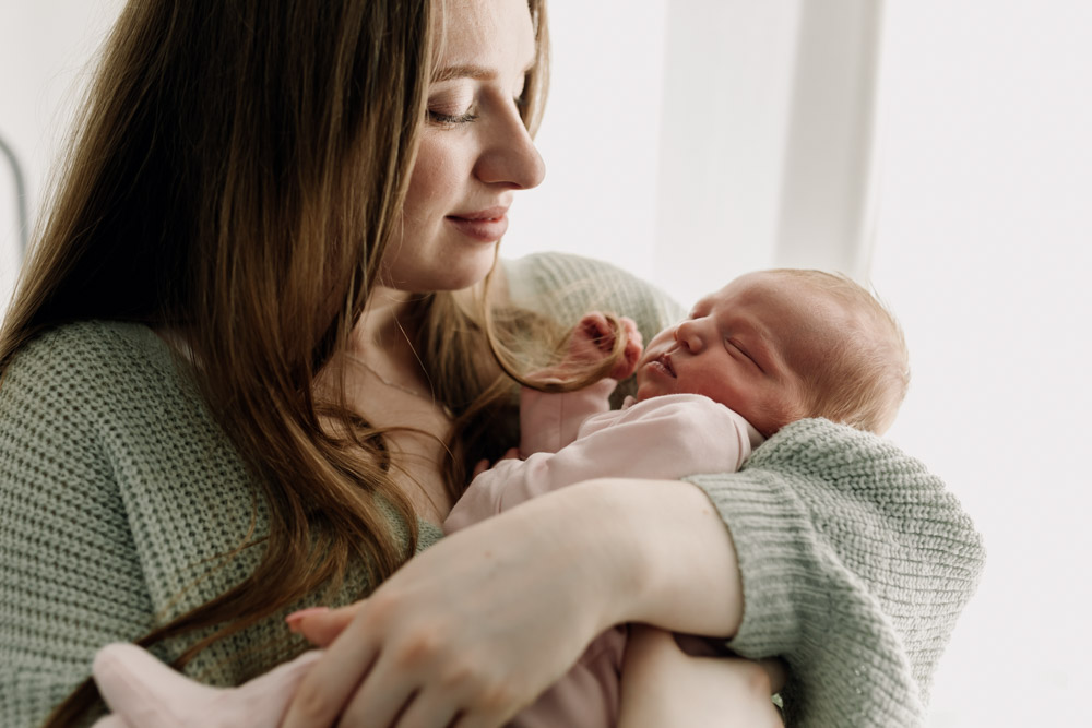 Newborn photo session in Basingstoke 19.01.24-13 mum is holding her daughter in her hands. lovely newborn session at home. Basingstoke photographer. Ewa Jones Photography. Beautiful maternity and newborn photo session