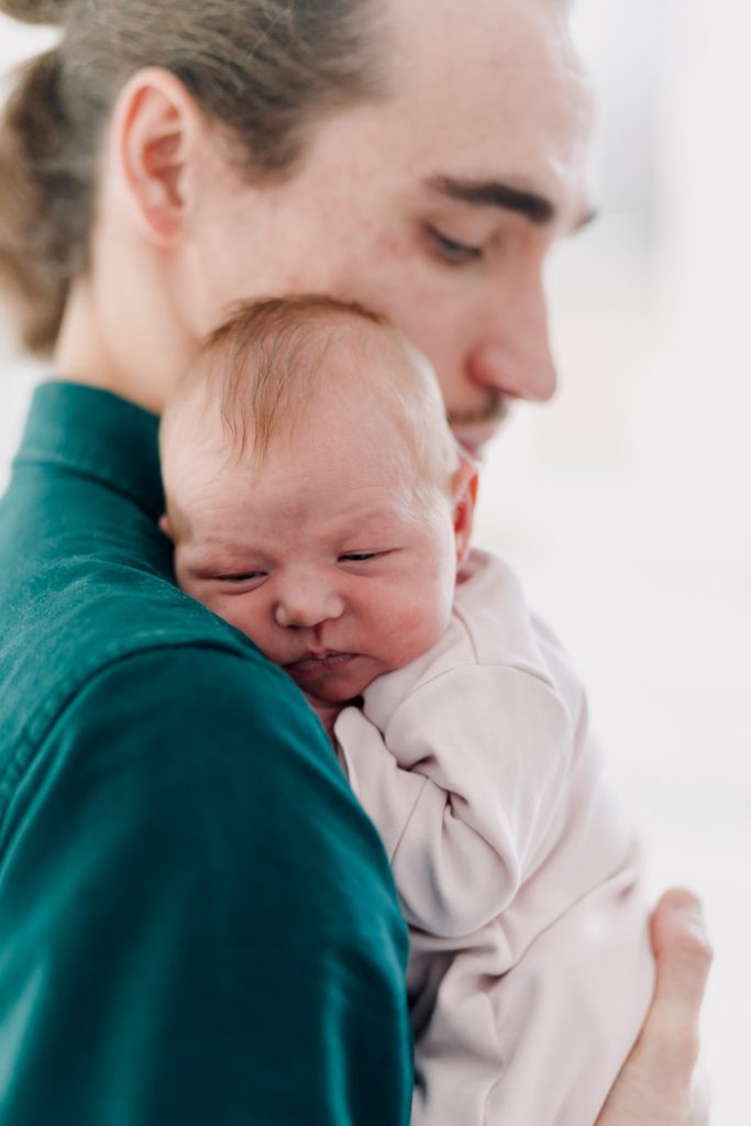 Newborn photo session in Basingstoke 19.01.24-7 dad is holding close his baby girl. what to wear for a newborn session. Ewa Jones Photography. Beautiful maternity and newborn photo session