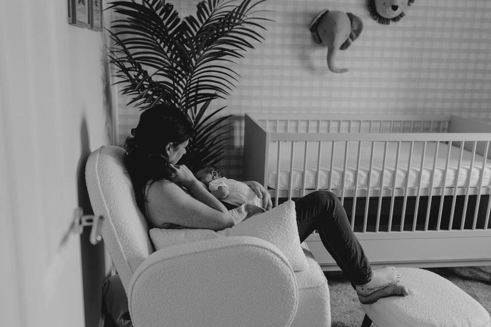 Mum is breastfeeding in the baby nursery room. lovely intimate session. newborn session in Hampshire. Ewa Jones Photography