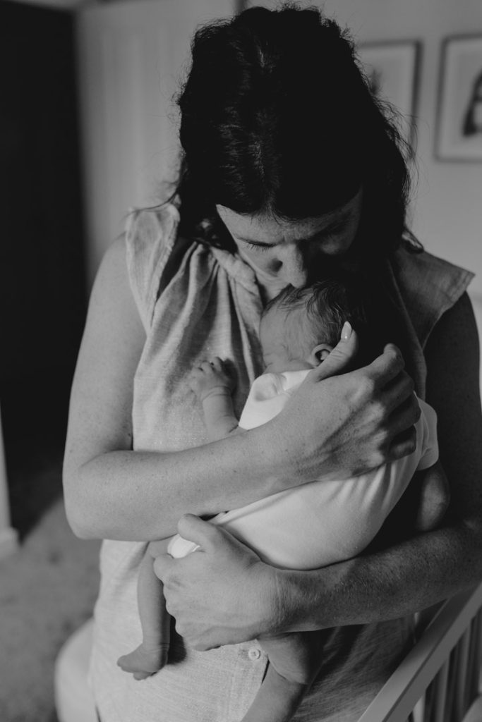mum is cuddling close her newborn baby. Hampshire newborn session in Basingstoke. In home session. Ewa Jones Photography