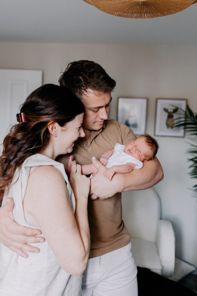 Parents are in baby nursery and cuddling close baby. Newborn photo shoot in Hampshire. Basingstoke photographer. Ewa Jones Photography