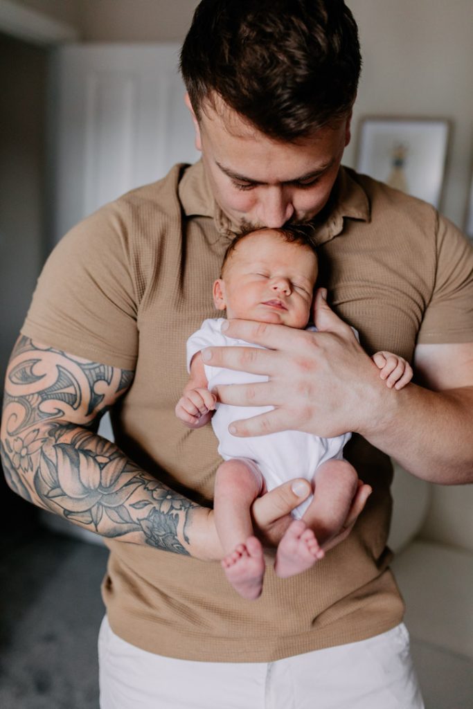 Dad is kissing his baby girl. Newborn session in Basingstoke. What to wear for a newborn session. Ewa Jones Photography