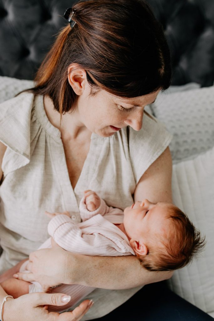 Mum is holding her baby girl in her arms. Newborn photo session in Basingstoke. Hampshire newborn photographer. Ewa Jones Photography