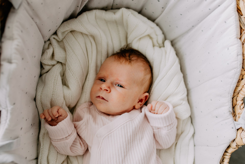 Baby girl is in her baby crib. in home newborn photo session. Hampshire newborn photo shoot. Ewa Jones Photography