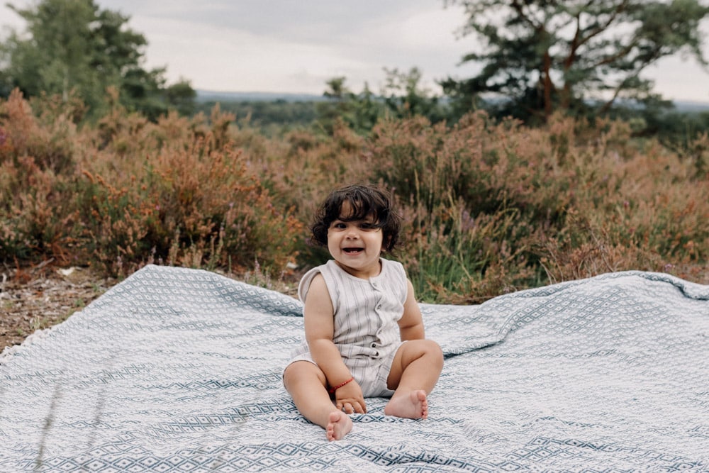 Little boy is looking and smiling at the camera. what to wear for a family session. Outdoor family photoshoot. Ewa Jones Photography