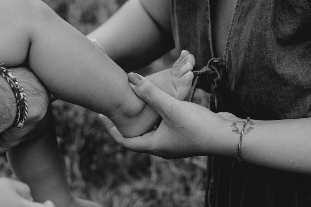 Close up of little baby boy foot. details during family photo session. Black and white image. Family photographer. Ewa Jones Photographer