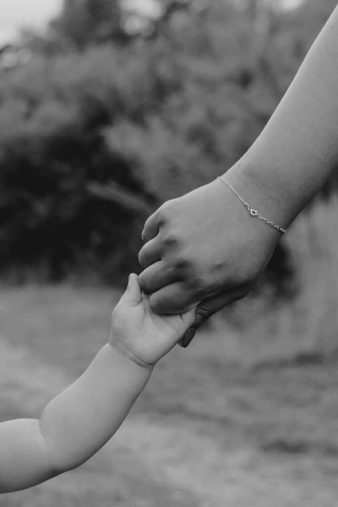 mum is holding her little son hand. intimate close up black and white image. Hampshire family photo session. Ewa Jones Photography