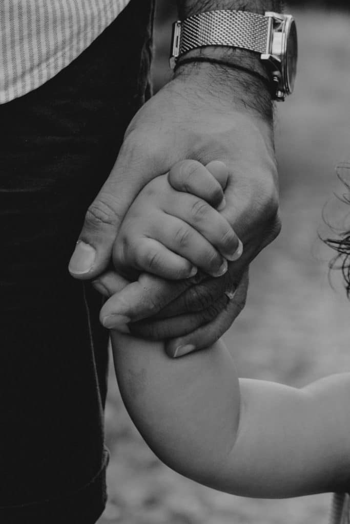 dad is holding his boy hand. black and white image. family photo session. Ewa Jones Photography. Hampshire and Basingstoke family photographer