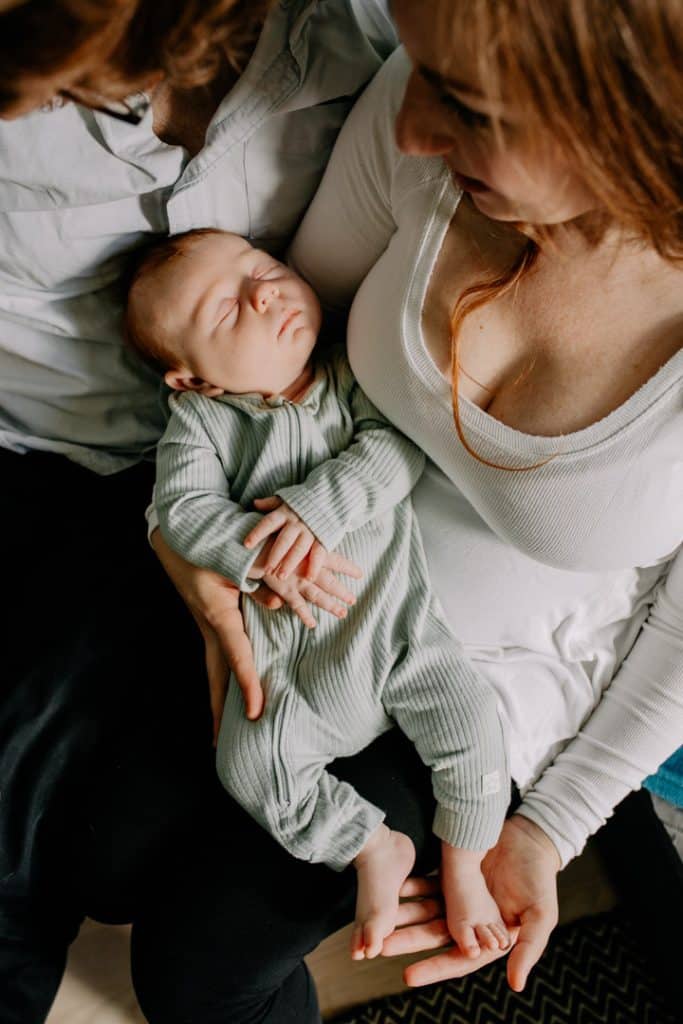 Baby boy is in mums arms and sleeping. London newborn photo shoot at home. Hampshire photographer. Newborn photo session. Ewa Jones Photography