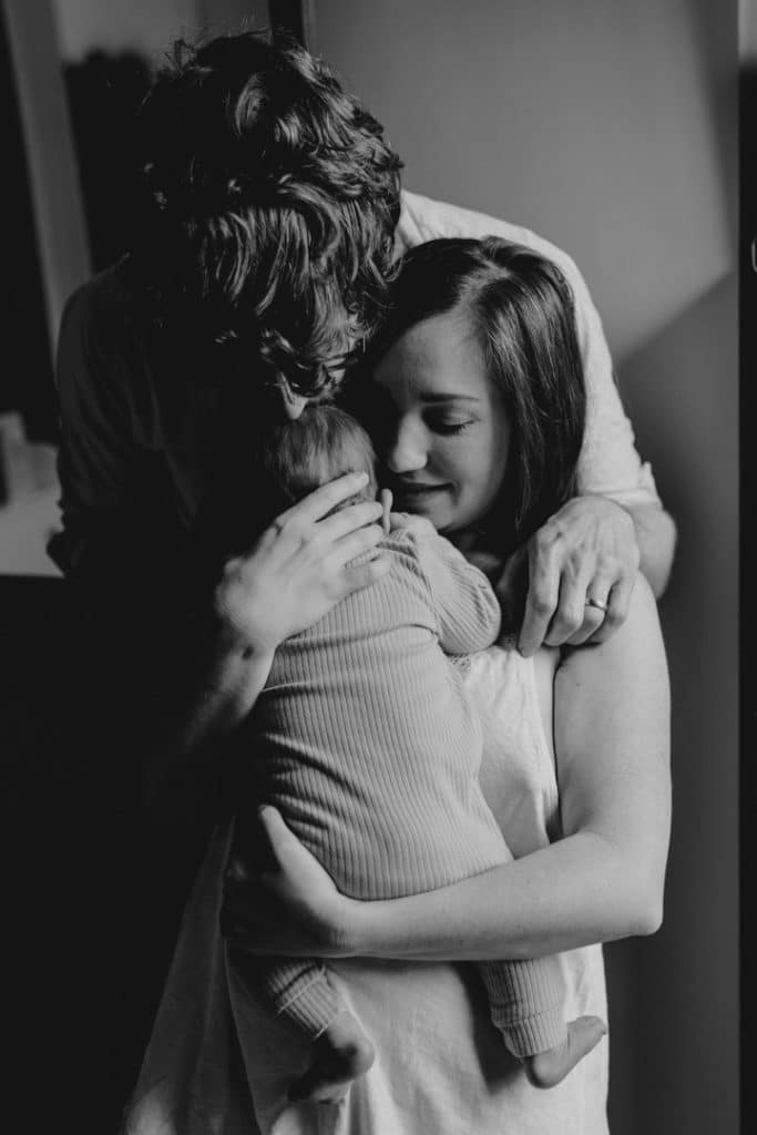 Mum and dad are cuddling close. Newborn photo session in home. Intimate newborn session. Basingstoke photographer. Hampshire newborn photo shoot. Ewa Jones Photographer