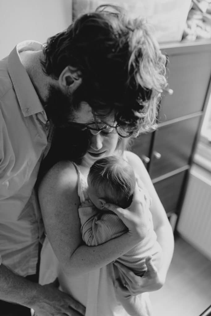 Mum and dad are cuddling close. Newborn photo session in home. Intimate newborn session. Basingstoke photographer. Hampshire newborn photo shoot. Ewa Jones Photographer