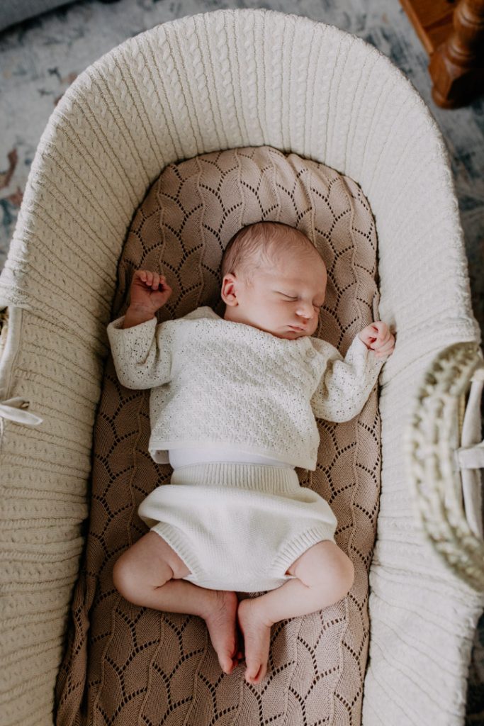 Newborn baby boy is laying in the Moses basket. natural lifestyle newborn photo session. Ewa Jones Photography