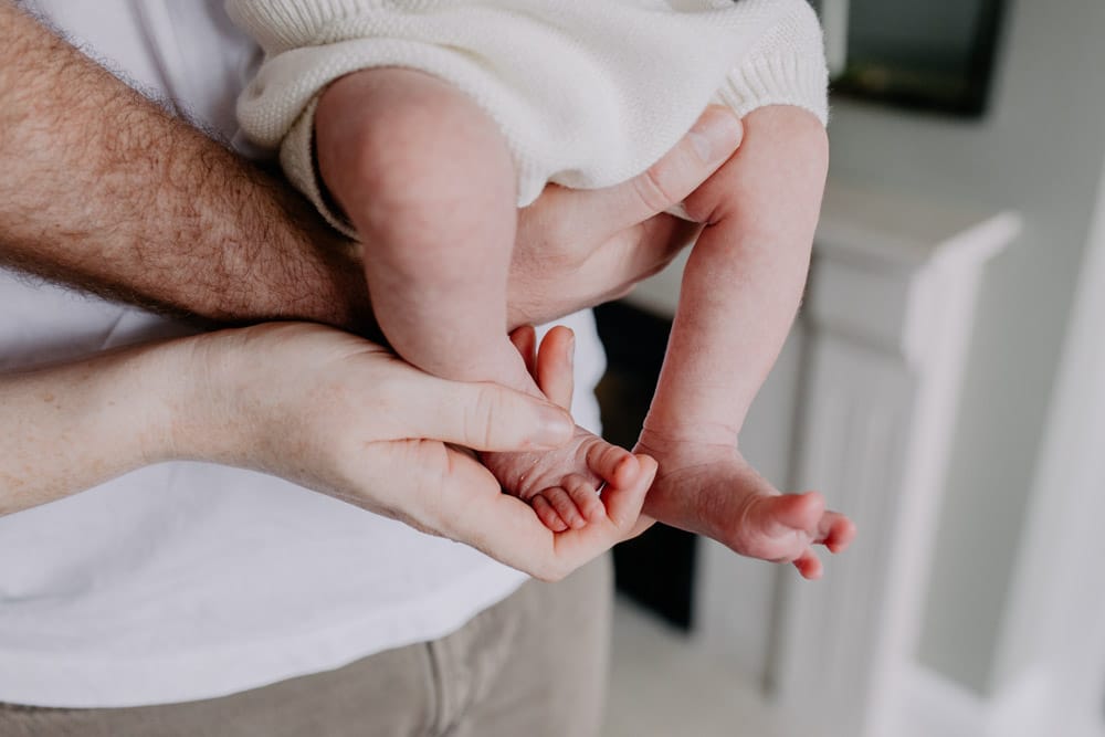 Intimate details, baby's feet. Dad holds newborn feet. Lovely natural newborn photography at home. Lifestyle newborn photo sessions. Hampshire photographer. Ewa Jones Photography