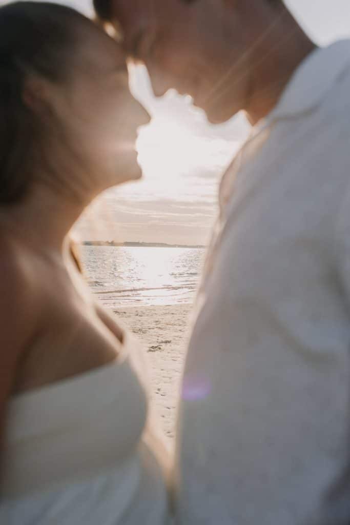 Parents to be are close to each other looking at each other. Sea is in the background. maternity photo session at the beach. The parents-to-be were glowing with joy. Ewa Jones Photography