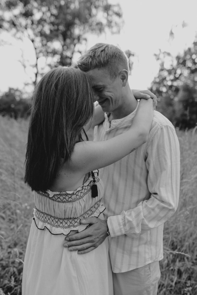 Expecting parents are looking at each other and cuddling. Maternity photo session in Hampshire. Family photographer in Hampshire. Hampshire photographer. Ewa Jones Photography