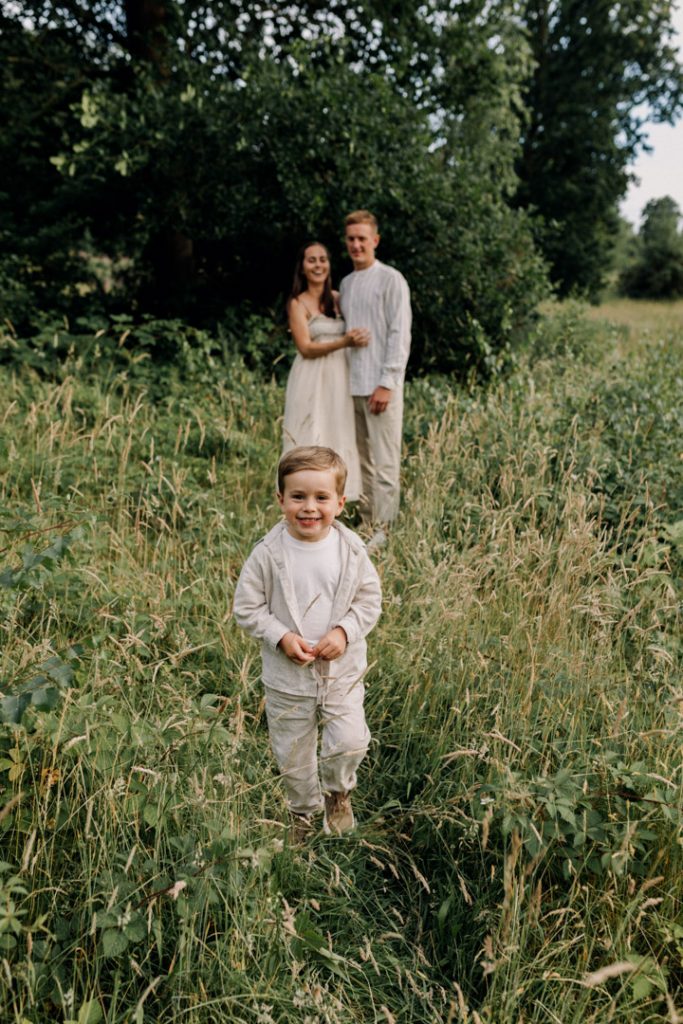 Boy is wearing natural clothes and walking towards the camera. Family photo shoot outside. Basingstoke family photographer. Hampshire photo shoot. Ewa Jones Photographer