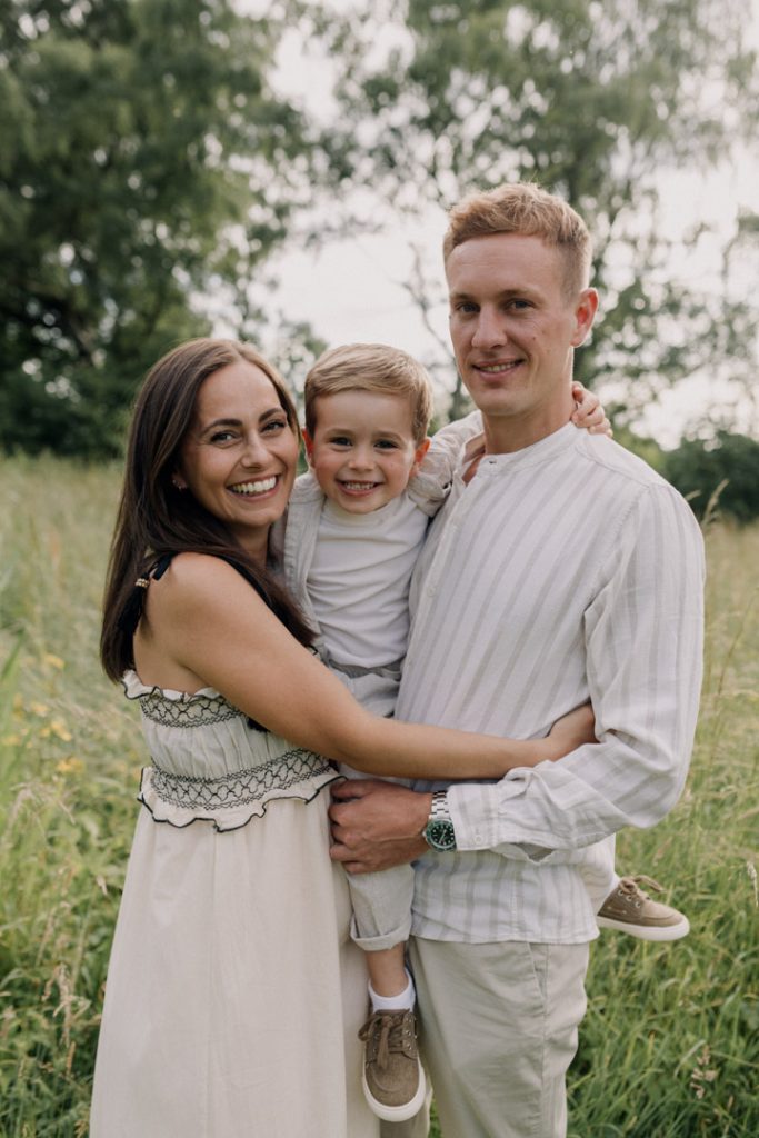 Family is looking at the camera and smiling. They are wearing lovely clothes. family photo session outdoors. Family photographer in Hampshire. Hampshire photographer. Ewa Jones Photography. Basingstoke photographer