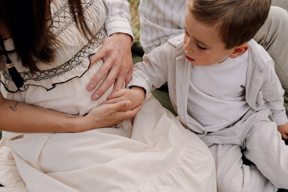 Boy is touching baby bump. Mum and dad are holding baby bump too. maternity shoot. Hampshire photo shoot. Hampshire photographer. Ewa Jones Photographer