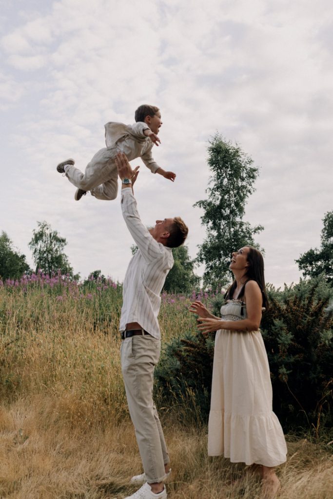 Dad is lifting his boy into the air. fun without posing family photo shoot. family session. Basingstoke photographer. Hampshire photo shoot. Ewa Jones Photography