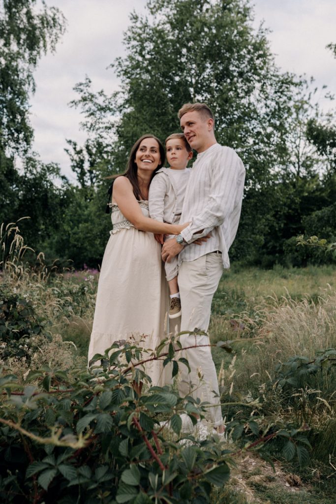 family of three is looking away and smiling. what to wear for a family session. How to prepare for a family photo shoot. Hampshire photographer. Ewa Jones Photographer.