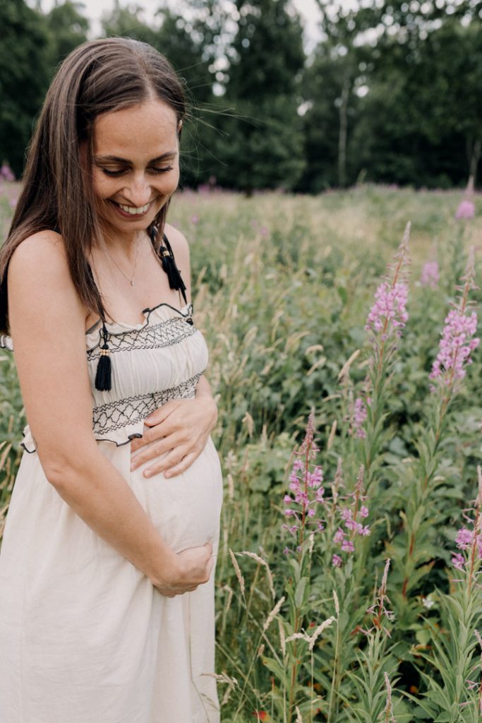 close up of mum cuddling baby bump. natural outdoor maternity photoshoot. Basingstoke photographer. Hampshire outdoor photo shoot. Ewa Jones Photographer