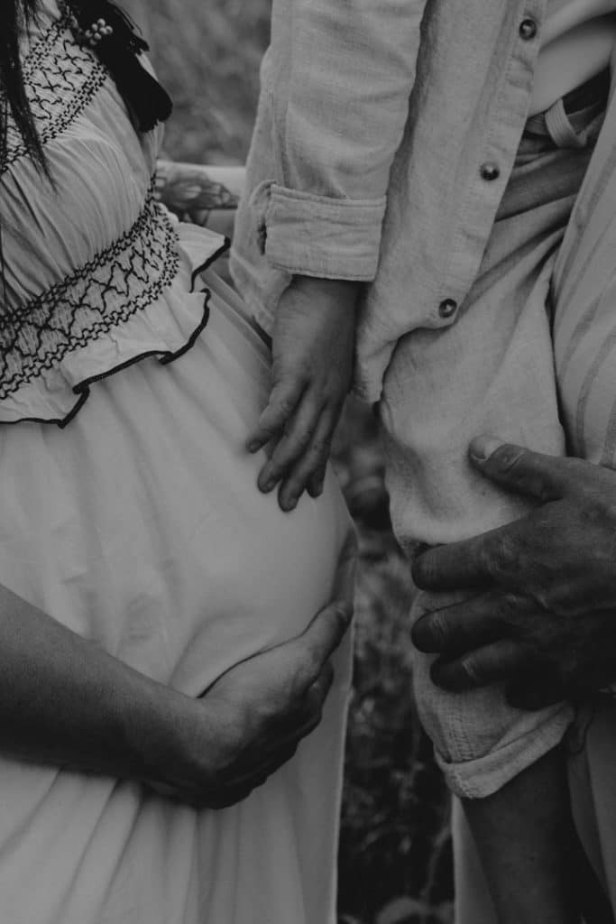 Black and white close up baby bump and little boy touching a bump. Family photo session. What to wear for family session. Family photographer in Hampshire. Hampshire photographer. Ewa Jones Photography