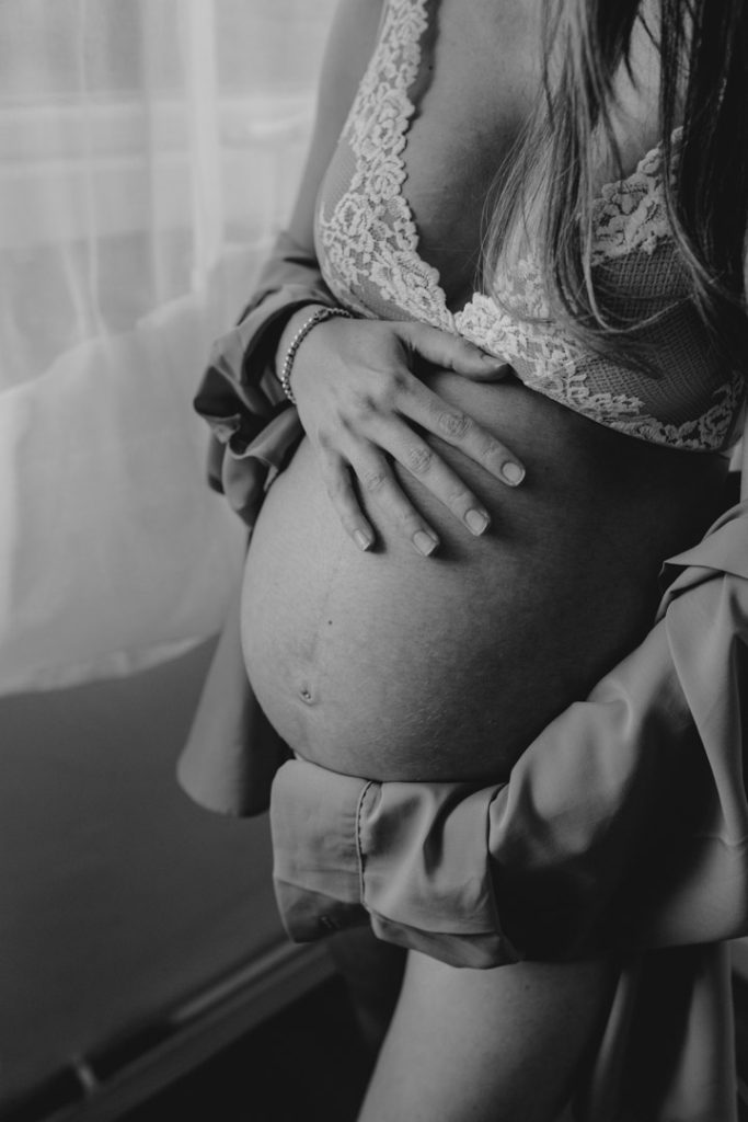 Pregnancy in home photography. Bump photo session. Black and white image of mum holding baby bump. Maternity session in home. Hampshire photo session. Ewa Jones Photography